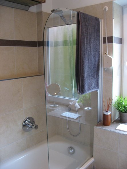 Badewanne mit Duschmöglichkeit und Ablage für Shampoo und Co.