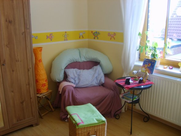 Ein gemütlicher Platz aus einem alten gut eingesessenen Sessel mit einem Überwurf mit Beistelltisch. Der Wäschekorb dient gleichtzeitig auch als Fußab